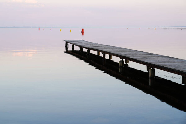 wood pontoon on morning sunrise on Lake Hourtin in Gironde france