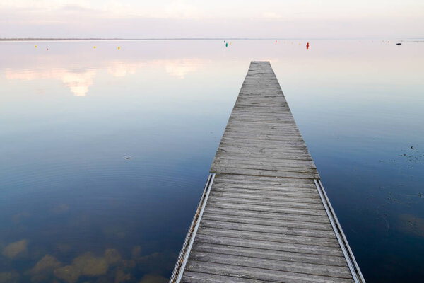 blue sunrise on fishing boat wooden pontoon in sunset Lake Hourtin in Gironde france