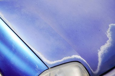 Araba mavisi, soluk motor kaputu ve zamanla aşınmış boya.