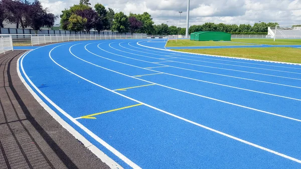 Athletics running blue track in a sports stadium