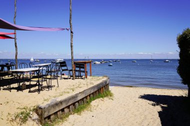 Teras istiridye lokantası deniz kenarında boş sandalyeler ve ahşap masa Cap Ferret France 'ın L' herbe plaj köyünde.
