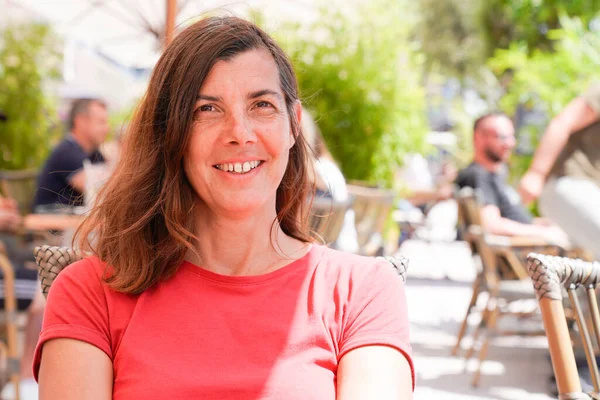陽気で美しい女性が夏の日にカフェレストランテーブルの屋外に座り — ストック写真