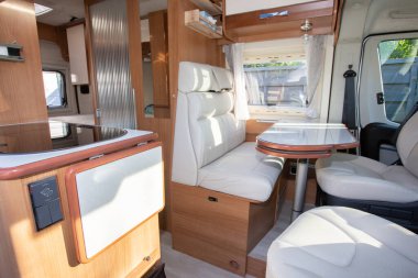 Karavan kampı yemek odası alanı. Vanlife sırasında karavanın içinde beyaz ahşap bir iç mekan.