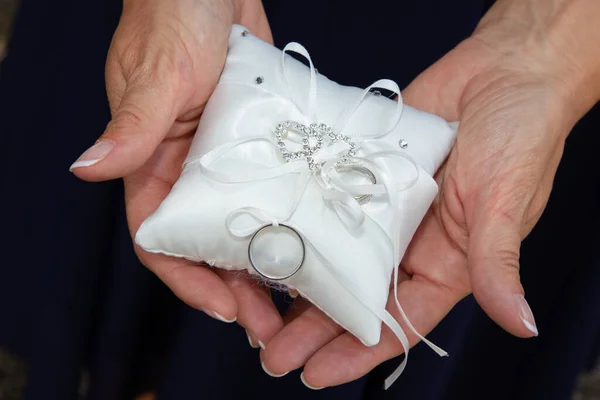 Два Обручальных Кольца Белой Подушке Над Руками Невесты — стоковое фото