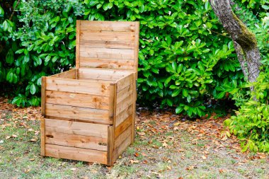 Worm composting wooden composter box in home garden clipart