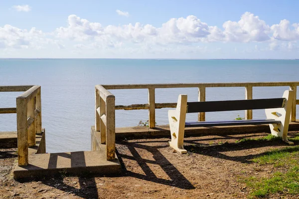 bench at the top of the stairs pedestrian access to the sand of the beach