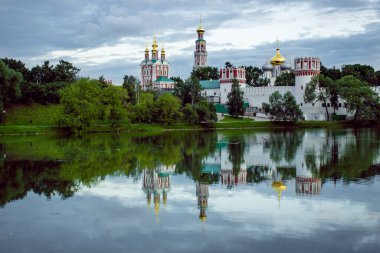Moskova 'daki Novodevichy Manastırı bulutlu bir havada. Göletten yansıyan güzel yansıma.