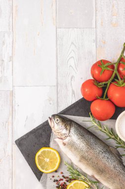 Zeytinyağı, domates, biber, tuz ve limonlu taze çiğ alabalık. Sağlıklı Akdeniz yemekleri, manzaralı, düz. Metin için boş alan.