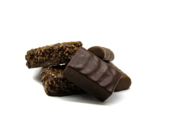 Kuş sütlü çikolatalar, ezilmiş fındıklar ve beyaz arka planda izole edilmiş yakın plan bir bar.