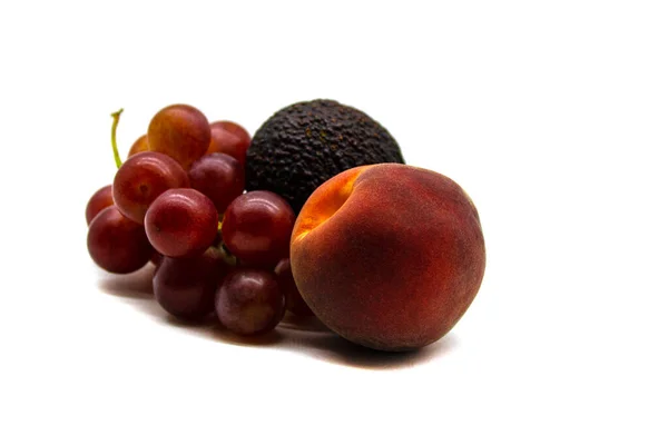 Ein Traubenstrauß Eine Avocadofrucht Und Ein Pfirsich Nahaufnahme Isoliert Auf — Stockfoto