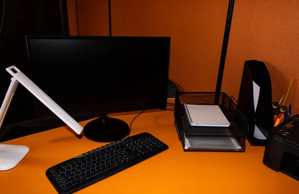Office workplace: computer, paper trays, lamp, printer, orange Desk