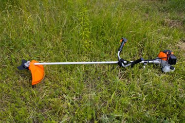 Yeşil çimenlikteki budama fırçalı benzin motoru