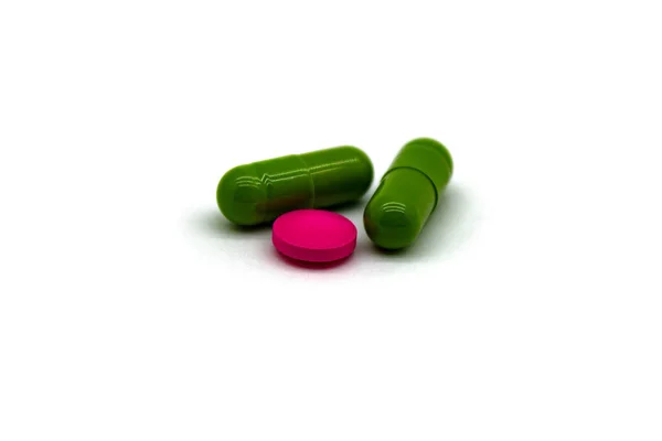 Due Capsule Medicinali Colore Verde Una Compressa Colore Rosa Vicino — Foto Stock