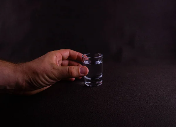 Mão Homem Com Copo Vodka Close Fundo Marrom Escuro — Fotografia de Stock