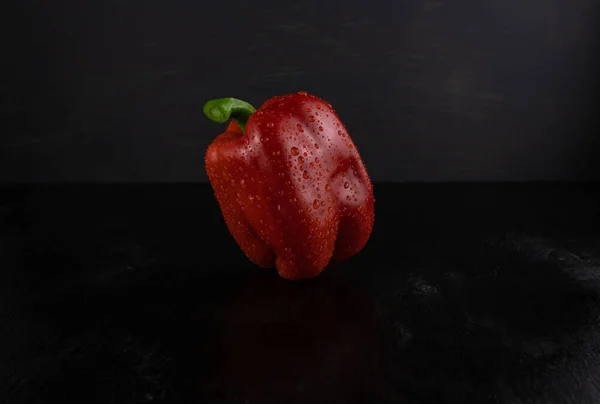 水中的红辣椒在黑暗的木制背景上滴着特写 — 图库照片