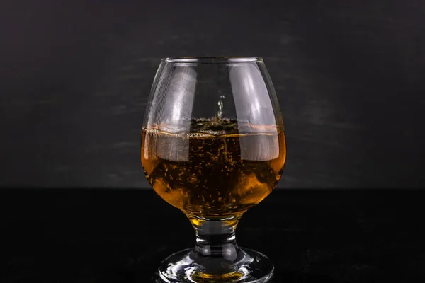 Een Glas Cognac Met Druppels Close Een Donkere Houten Achtergrond — Stockfoto