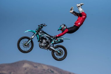 Kırmızı kostümlü dublör binici Motosiklet koltuk için gökyüzünde atlama üzerinde uçan U Rodeo, Ventura County Fair üzerinde 12 Ağustos 2018 California sırasında yolculuk ederken asılı.