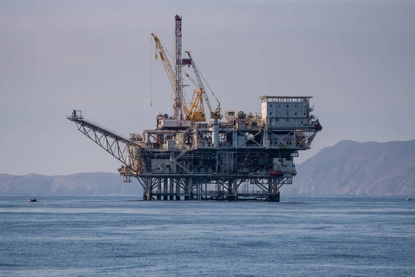 Platform Gina towers above the calm ocean surface with Anacapa Island silhouette in the distance.