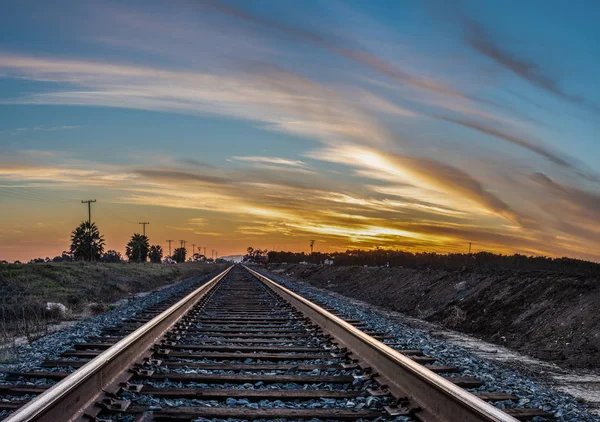 Parallel Verlaufende Bahngleise Vorbei Landwirtschaftlichen Feldern Und Den Bunten Sonnenuntergang — Stockfoto