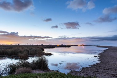 Dawn'a okyanus lagün, daha düşük gelgit gölette pürüzsüz ve yansıtıcı yüzeyi üzerinde önde gelen kırmızı ufuk parlak.