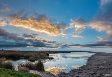 Şafak okyanus lagün, daha düşük gelgit gölette pürüzsüz ve yansıtıcı yüzeyi mimiced parlayan bulutlar.