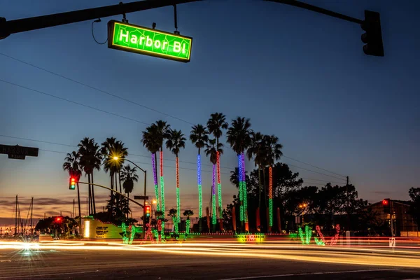 Traffic Lights Streaking Vehicles Cross Intersection Sun Sets Holiday Lights — Stock Photo, Image