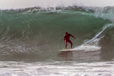 Siyah wetsuit çok büyük varil içine bırakarak Goofy ayak sörfçü dalgaları kış swell Santa Barbara, Kaliforniya, ABD'de 9 Ocak 2019 ayarla.