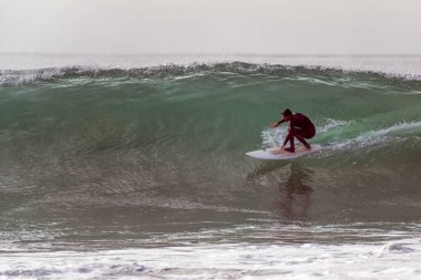 Sağda büyük dalgalar Santa Barbara, Kaliforniya, A.b.d. kış swell üzerinden 9 Ocak 2019 üzerinde giderken şekillendirme varil içine crouching hood, giyen içinde normal ayak sörfçü.