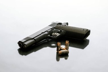 Hefty 1911 yarı otomatik tabanca. 4 boş uçlu merminin yanına yerleştirilmiş. Ev korumasını suçtan korumak için iyi bir seçim..
