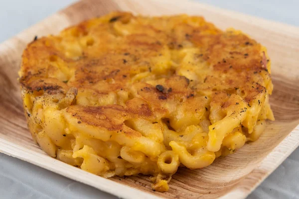 Home cooked meal includes baked macaroni and cheese in a circle and will taste as delicious as it looks.