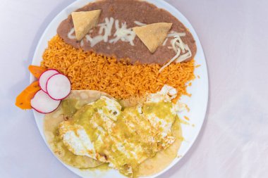Yumurta, pirinç ve fasulye gibi lezzetli Meksika yemekleri için sıcak bir tabakta servis edilir..