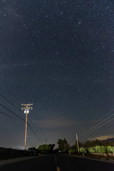 Dark road through the country side guided only by the stars to navigate toward destination.