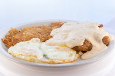 Köy sosuyla sulanan kızarmış biftek, yumurta ve patates kızartmasının cömertçe sunduğu yemek..