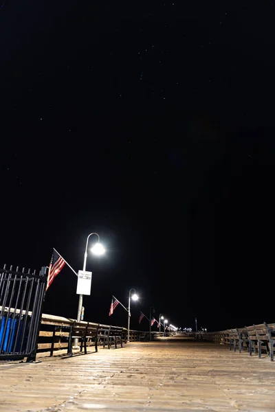 桟橋のランプは 夜の空のオリオン座と他の星の星座の下のベンチュラ桟橋の木製の歩道を照らす — ストック写真