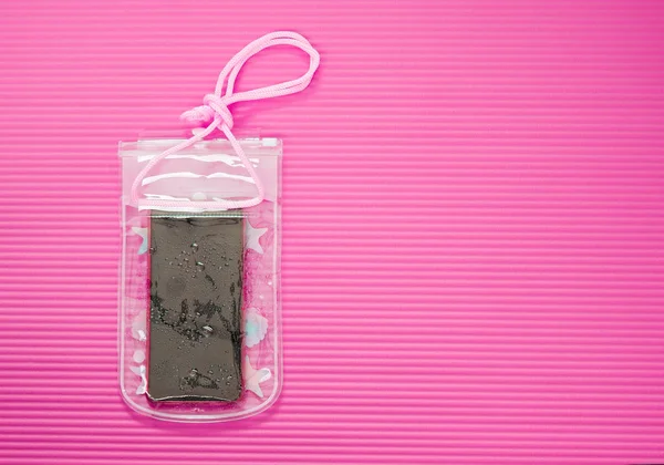 Waterproof Mobile Phone Case with Water Droplets Isolated on Pink Mat Background. Plastic PVC Waterproof Case for Smartphone, Zip Lock Bag Protect. Thai New Year or Songkran Water Festival in Thailand.