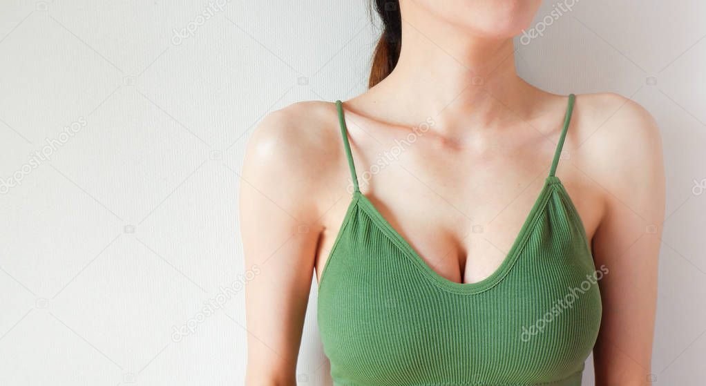 Woman is Breast in Green Underwear Posing on Grey Background,Show the Bra. Cropped Close Up of Sexy Female Wearing Sport Bra (Sportswear) with Perfect Chest. Fitness and Yoga Healthy Lifestyle Concept.