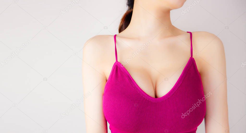 Woman is Breast in Pink Underwear Posing on Grey Background,Show the Bra. Cropped Close Up of Sexy Female Wearing Sport Bra (Sportswear) with Perfect Chest. Fitness and Yoga Healthy Lifestyle Concept.