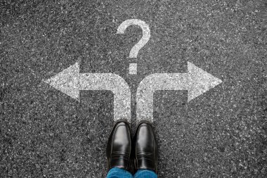 Grunge beton üzerinde duran işadamı siyah ayakkabı üst görünümü. Beyaz soru işareti ve sol veya sağ oklar ile Adam ayakları gelecekteki yaşam için yol arka plan üzerinde işareti. Karar verme nin seçim kavramı.