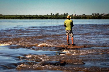Pescardor en el Rio Uruguay, en el fondo se observa el Department amento de Uruguaiana Brasil