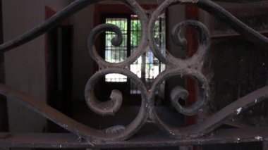 Vista parcial a travs de una valla dentro de una vieja casa de barro abandonada