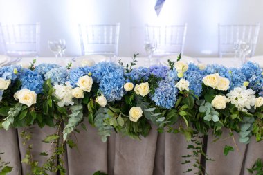 Ziyafet tablo ortanca çiçek ve yeşillik besteleri ile süslüdür