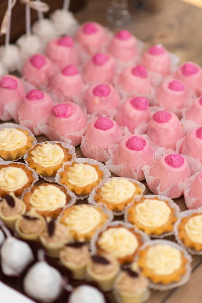 Pink and yellow cupcakes on banquet table. Wedding table setting