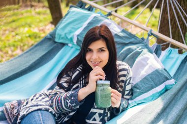 Mutlu sağlıklı yeme kız hamak yeşil smoothie detoks açık içme. Kilo kaybı diyet vegan beslenme temizlemek kadın.