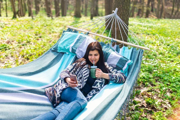 Happy Zdrowe Jedzenie Dziewczyna Picie Zielone Smoothie Detox Zewnątrz Hamaku — Zdjęcie stockowe