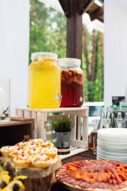 Nikah şekeri nin üzerine cam limonata kavanozları. Catering. Düğünde içki. Ormanda yaz düğünü. Zarif düğün masası aranjmanı