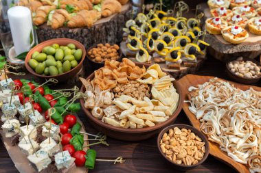 Kahverengi rustik ahşap ziyafet masasında lezzetli yemekler. Ormanda yaz düğünü