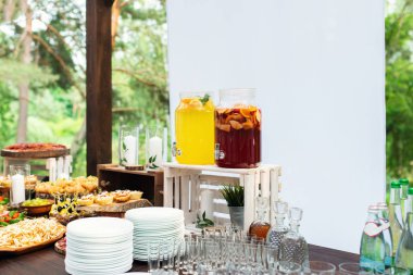 Nikah şekeri nin üzerine cam limonata kavanozları. Catering. Düğünde içki. Ormanda yaz düğünü. Zarif düğün masası aranjmanı