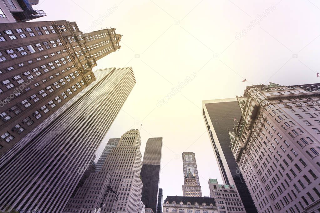 Vintage stylized photo of skyscrapers in Manhattan at sunset, New York City, USA. View up of building