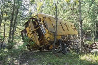 Güneşli bir gün mavi gökyüzü ile bir alanda ve bulutlarda yabancılaşma Chernobyl nükleer enerji santrali bölgedeki terk edilmiş ve paslı otobüs