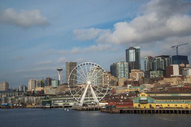 Seattle waterfront ve manzarası, Space Needle gösteren büyük tekerlek dönme dolap ön planda konuşmacı aracılığıyla ile. Geç öğleden sonra altın ışık ile renkli görüntü.